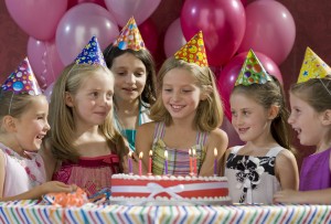 Young girls at a birthday party with cake